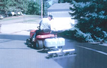 Using the towable EZ-Sealer Residential Sealcoat Machine to reseal the asphalt drivway